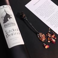 Крупен план на етикета на свещта 'Locked Desires' с прилеп вътре в клетка.